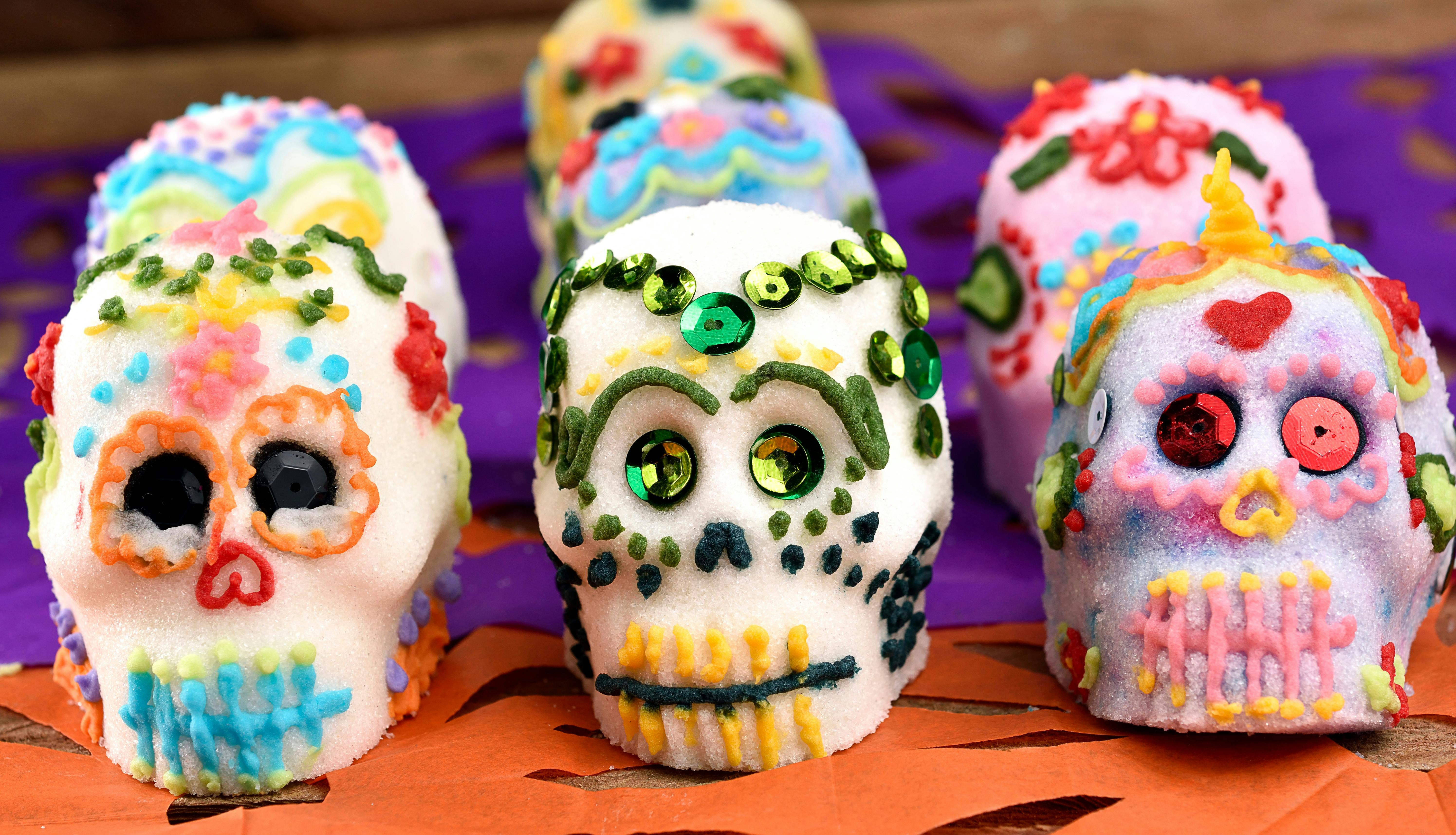 Elaborately decorated sugar skulls with names written on foreheads